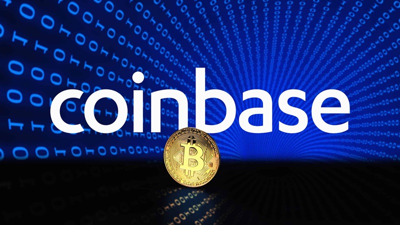 A Coinbase logója, amely a "coinbase" szót nagy, fehér betűkkel ábrázolja egy kék, digitális háttér előtt, tele 0 és 1 számokkal. A szöveg alatt egy arany Bitcoin érme látható, amelynek közepén a "B" szimbólum található. A háttér sugárzó, kék fényhatásokkal van kiemelve.